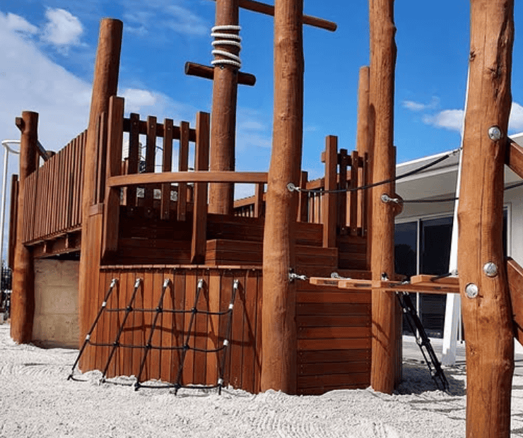 Wooden outdoor play structure with climbing ropes and slides, perfect for kids’ playgrounds and backyard entertainment. Durable timber design offers safe and fun outdoor activity space.