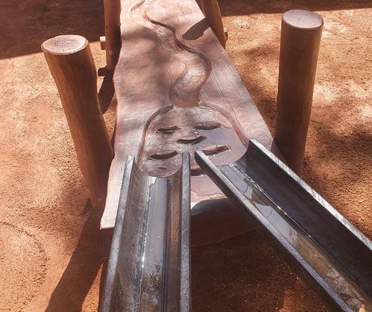 Handcrafted wooden and metal playground slide with natural wood finish and sturdy construction, ideal for children's outdoor play areas. Perfect for enhancing outdoor recreation spaces.