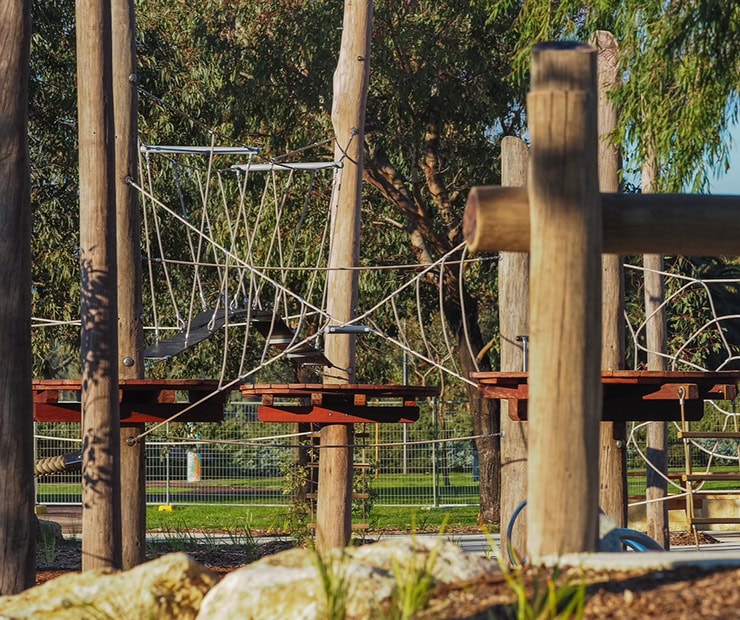 Climbing playground equipment with rope bridges and wooden structures for kids outdoor play area design.