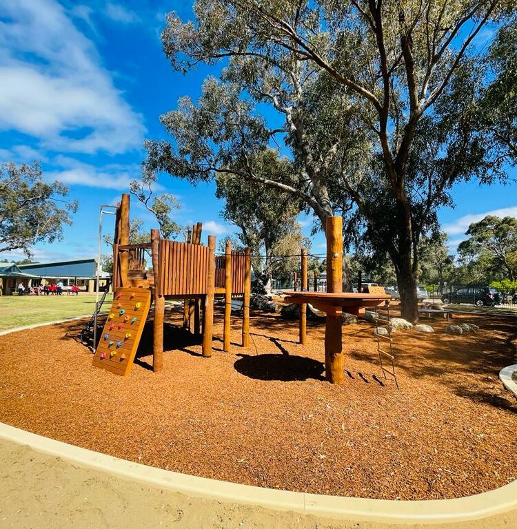 Outdoor playground with wooden structures, slides, and climbing features for children.